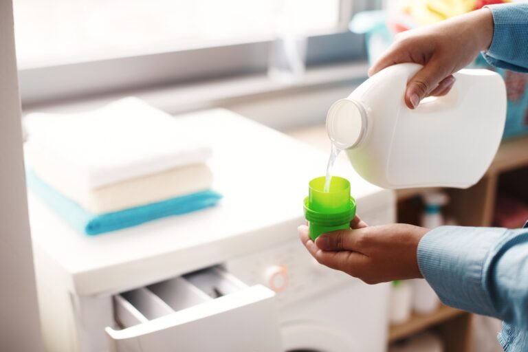 A housewife carefully doses the detergent to put in the washing machine
